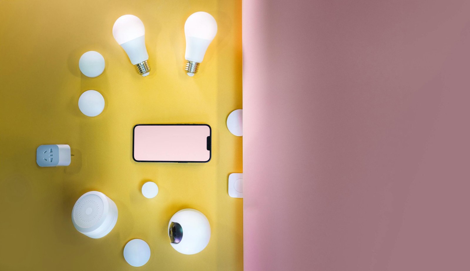 Flat lay of smart home devices with vibrant pink and yellow gradient background.